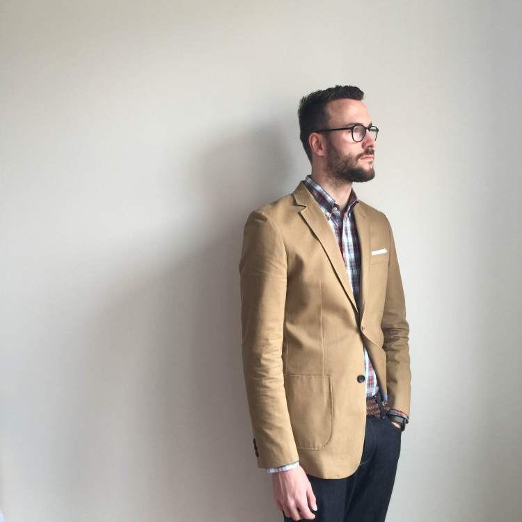 On the lookout for spring. Shirt by Gustin. Khaki Travel Jacket by Combat Gent. Pocket square by Banana Republic. Glasses by Warby Parker. Photo credit: Liz Todd.