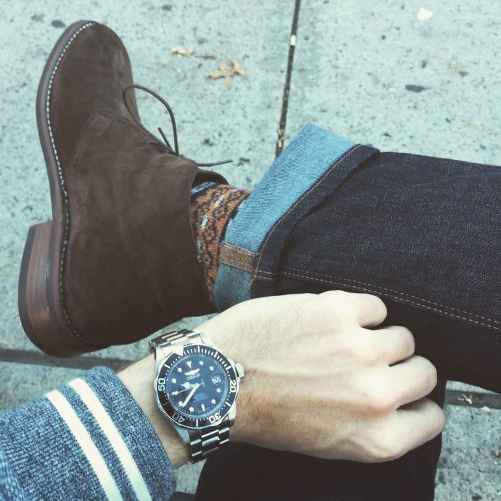 The boot hits higher on the ankle, a refined touch that stands out --in a good way. Fair Isle socks by American Trench. Baseball jacket by Grayers. Dark denim by Mott & Bow. Watch by Invicta.