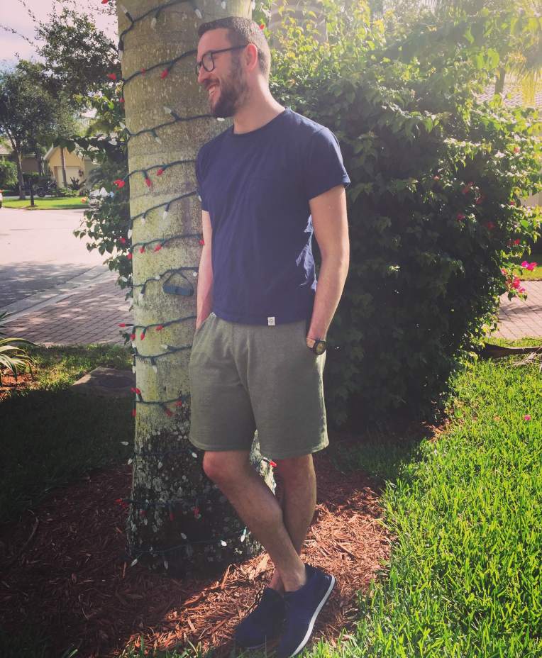 Dressed casually for a hot Florida day. Organic cotton pocket tee by United By Blue. Olive sweatshorts by Pistol Lake. Navy Rosen Runners by GREATS Brand. Eco-friendly watch by Sprout. Glasses by Warby Parker. 
